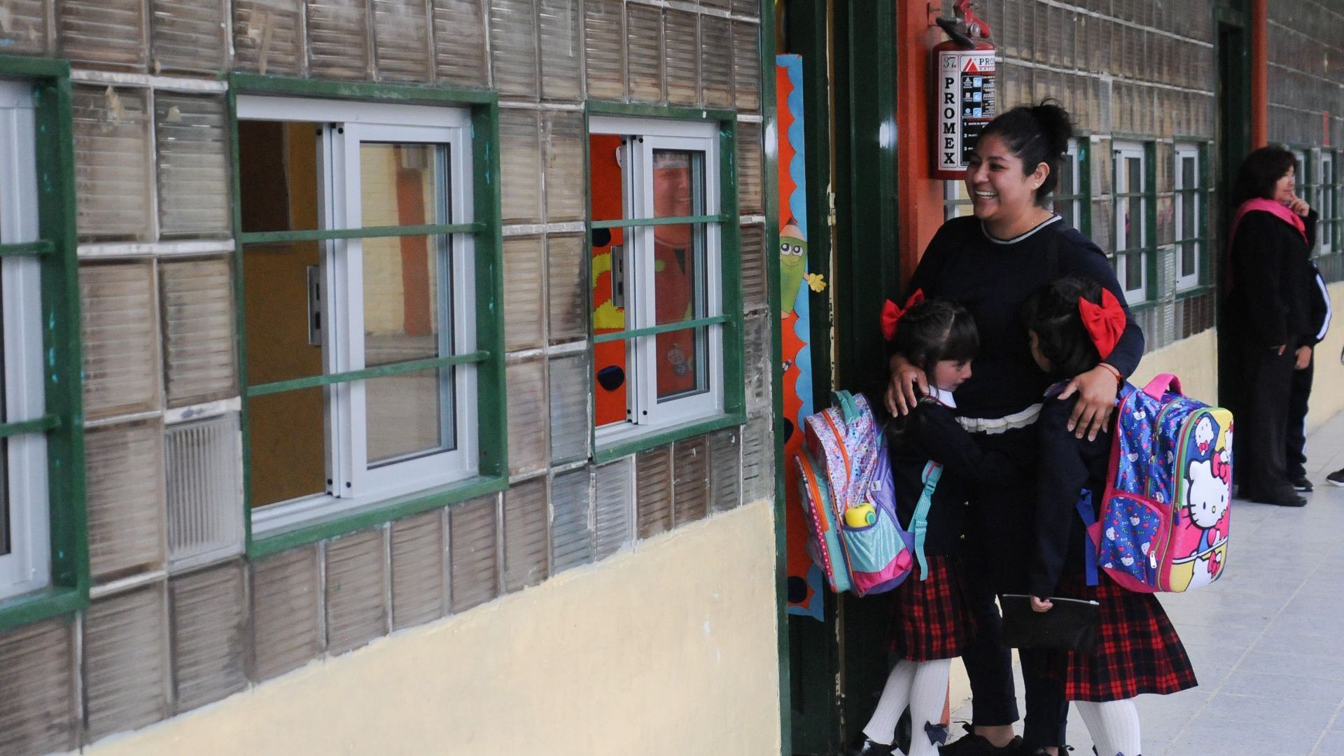 Una madre acompaña a sus dos hijas al salón de clases. Foto: Cuartoscuro